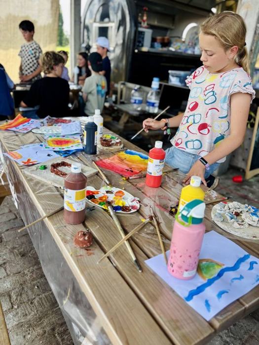Kinderen schilderen aan een lange tafel