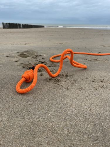 Het oranje rope flow touw van Mieke op het strand