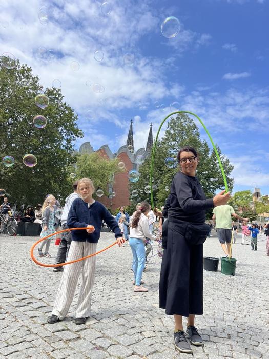 Mieke en een meisje doen rope flow tussen de zeepbellen op een plein